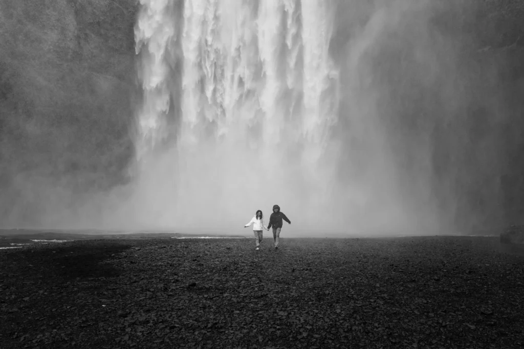 Black and white engagement photography at Skogafoss waterfall in Iceland.