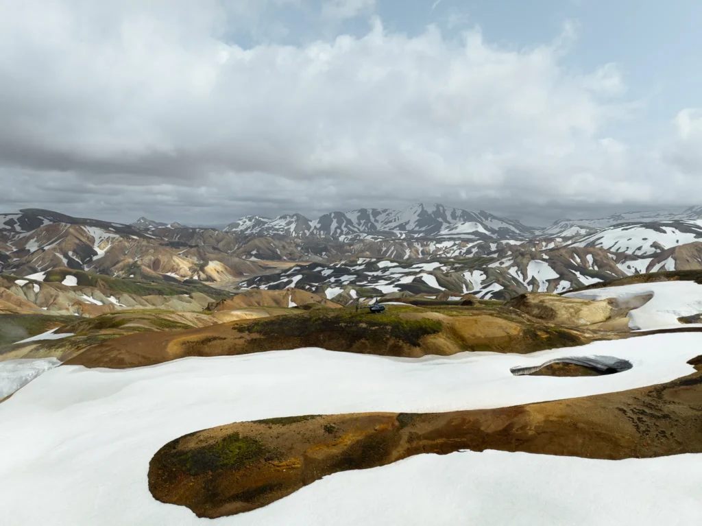 Landmannalaugar, Iceland – aerial view of colorful volcanic mountains, snow-covered valleys, and rugged highlands.