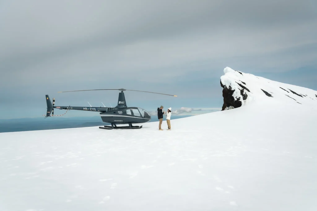 A woman showing her engagement ring while standing on a snowy glacier in Iceland.