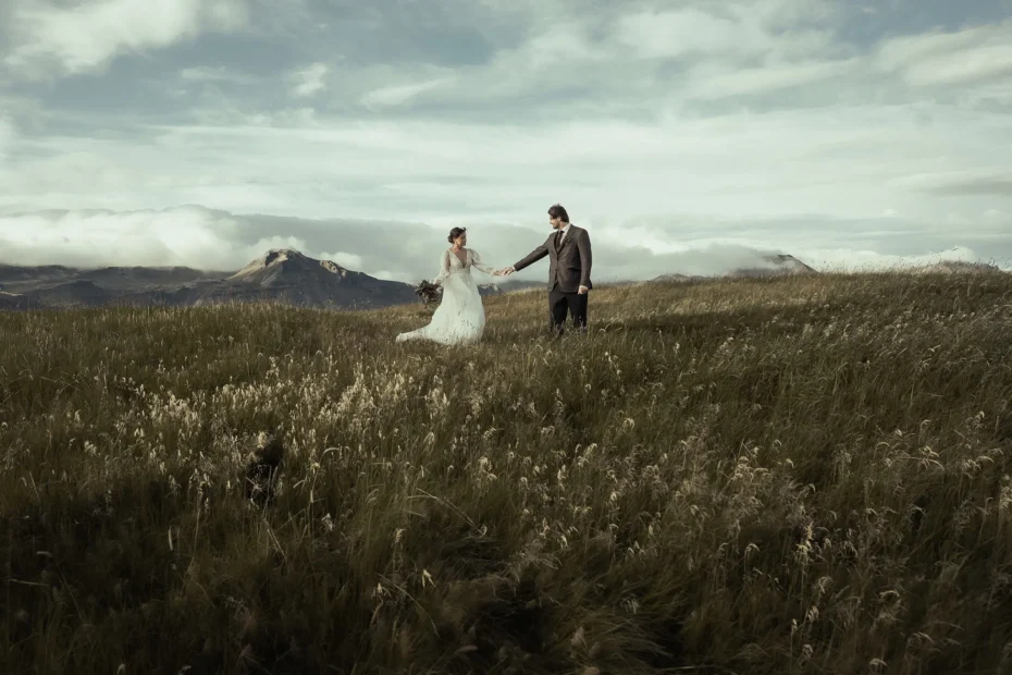 Elopement couple holding hands in a mountain meadow in Iceland during a destination wedding