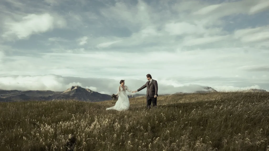 Elopement couple holding hands in a mountain meadow in Iceland during a destination wedding