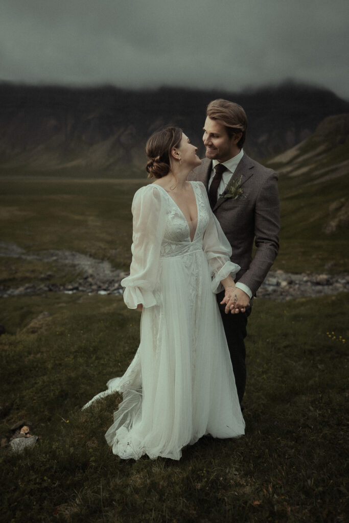 A bride and groom smiling at each other during their elopement near Grundarfoss in Iceland