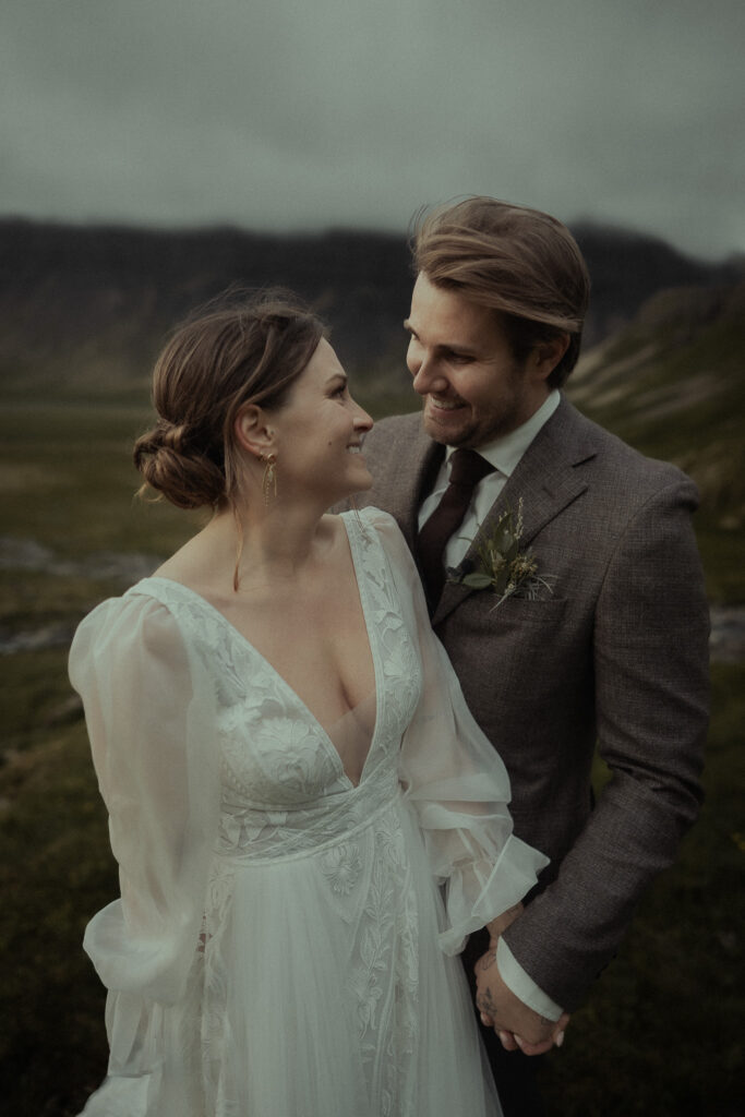 A bride and groom smiling at each other during their elopement near Grundarfoss in Iceland