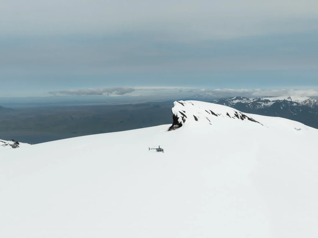 Helicopter landing on a glacier during an Iceland elopement, surrounded by snowy mountains