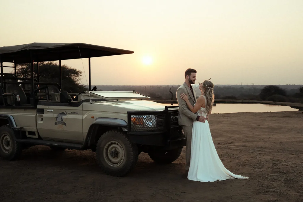 Bride and groom at sunset by a safari vehicle at Jabulani Safari Lodge in South Africa
